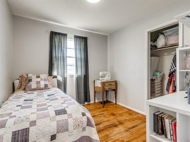 bedroom featuring a closet, baseboards, and light wood-style floors