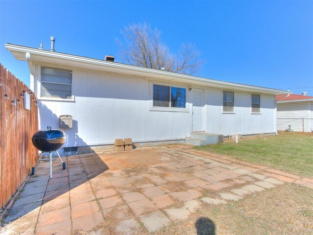 back of property featuring a patio, a lawn, and fence