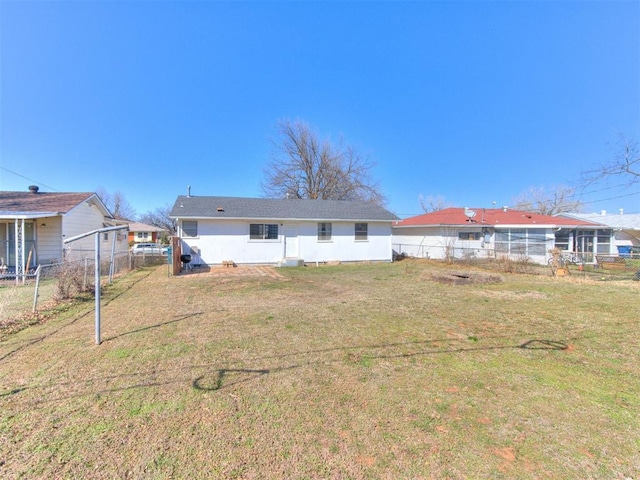 back of house featuring a yard and fence