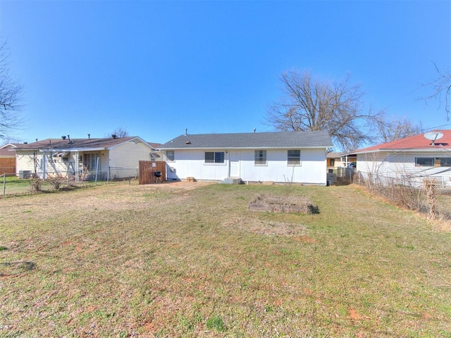 back of house featuring a yard and fence