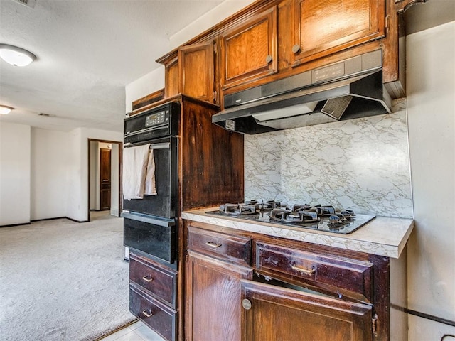 kitchen with a warming drawer, light countertops, under cabinet range hood, black oven, and light colored carpet