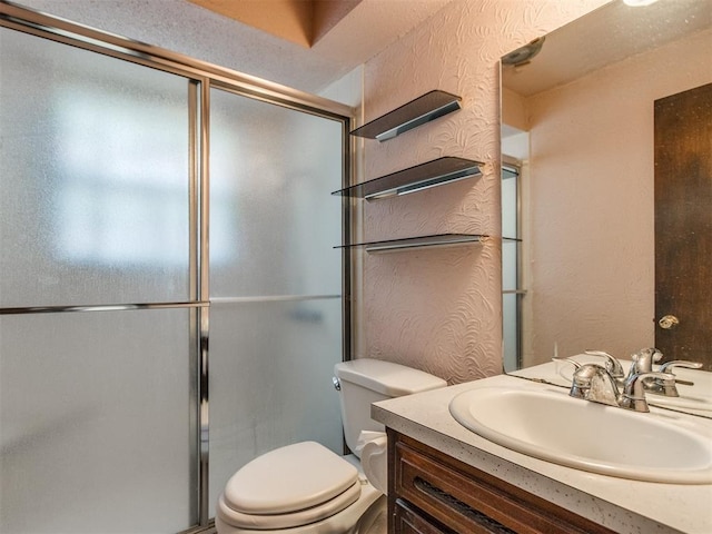 full bath featuring a shower with door, toilet, vanity, and a textured wall