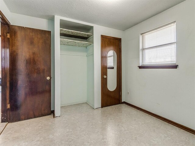 unfurnished bedroom with baseboards and a textured ceiling