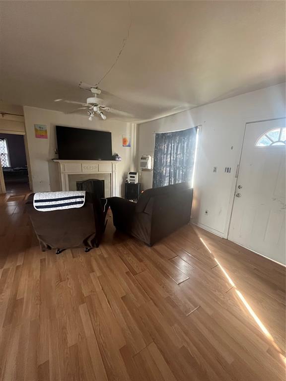 living room with a fireplace, wood finished floors, and ceiling fan