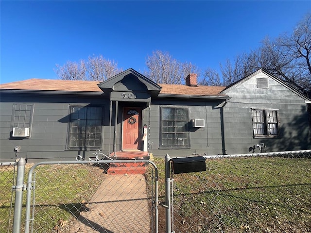 view of front of house with a gate, a fenced front yard, cooling unit, a front yard, and a chimney