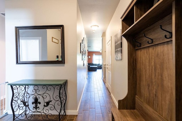 corridor with baseboards and wood finished floors