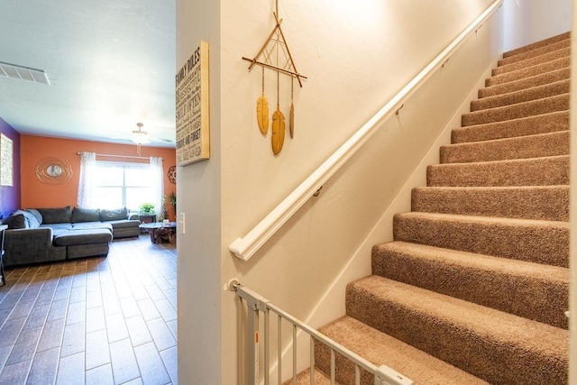 stairway with wood finished floors and visible vents