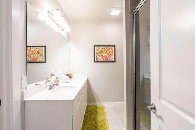 bathroom featuring tile patterned floors, a shower with door, a sink, double vanity, and baseboards