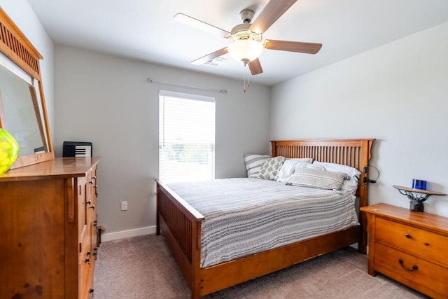 bedroom with visible vents, baseboards, light colored carpet, and a ceiling fan