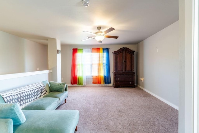 sitting room with light colored carpet, baseboards, and ceiling fan