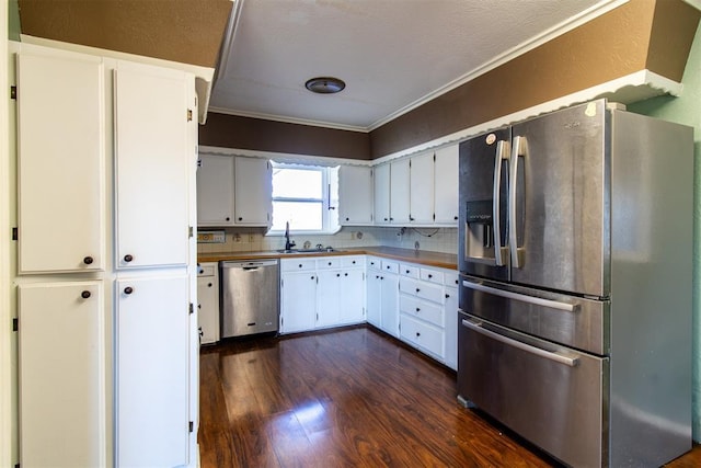 kitchen with tasteful backsplash, crown molding, dark wood-style flooring, stainless steel appliances, and a sink