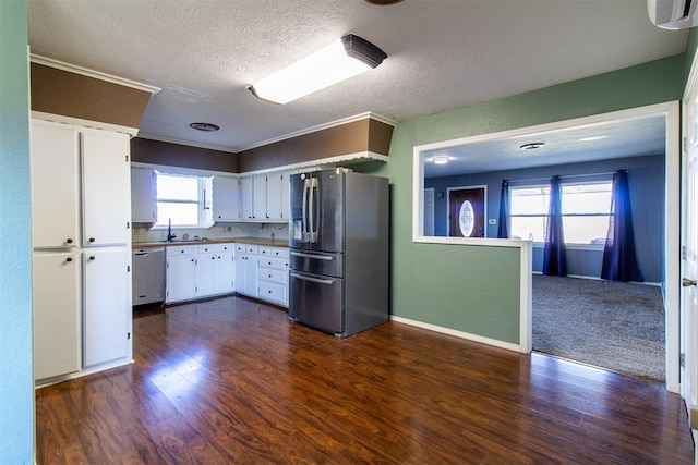 kitchen featuring dark wood-type flooring, appliances with stainless steel finishes, white cabinets, and a textured ceiling