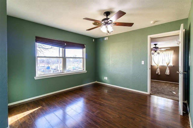 unfurnished room featuring a textured wall, a ceiling fan, baseboards, and hardwood / wood-style floors