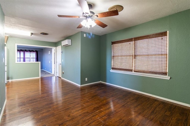 unfurnished room with wood finished floors, baseboards, ceiling fan, a wall mounted air conditioner, and a textured ceiling