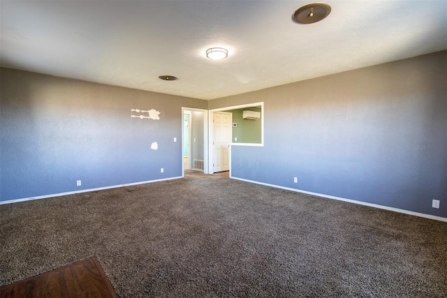 carpeted spare room featuring visible vents, baseboards, and a wall mounted AC