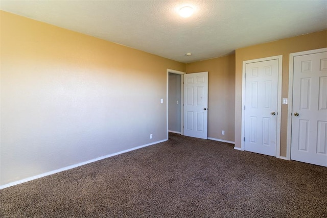 unfurnished bedroom with baseboards, carpet, and a textured ceiling