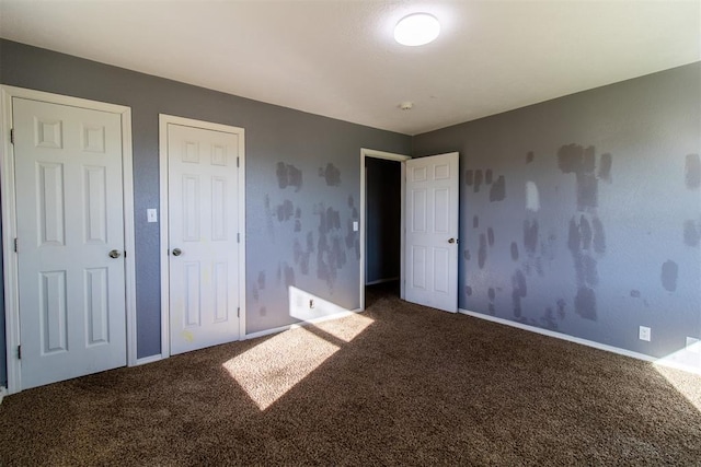 unfurnished bedroom with carpet and baseboards