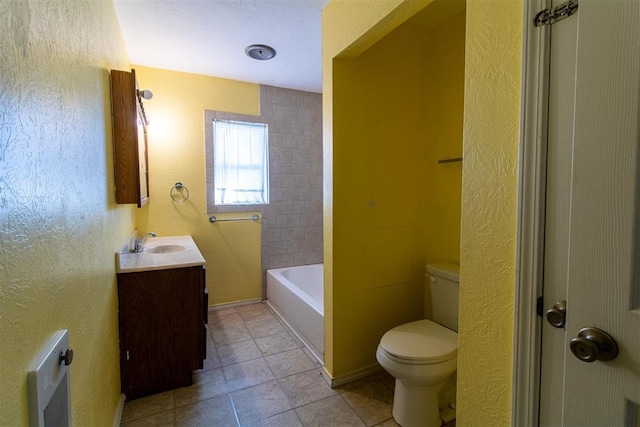 full bath featuring tile patterned floors, toilet, vanity, and a textured wall