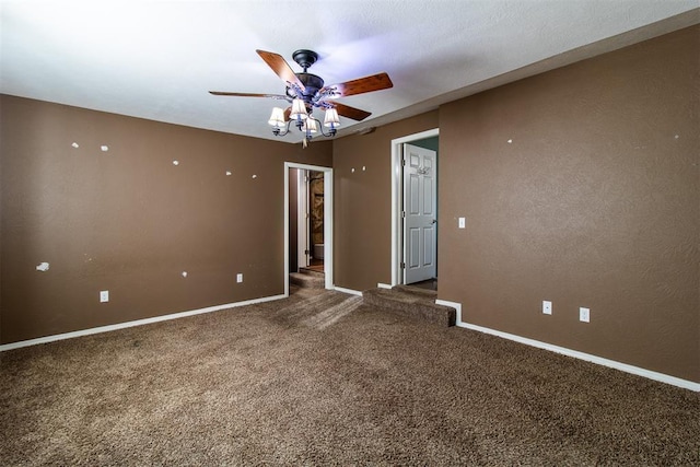 empty room featuring baseboards, carpet floors, and a ceiling fan