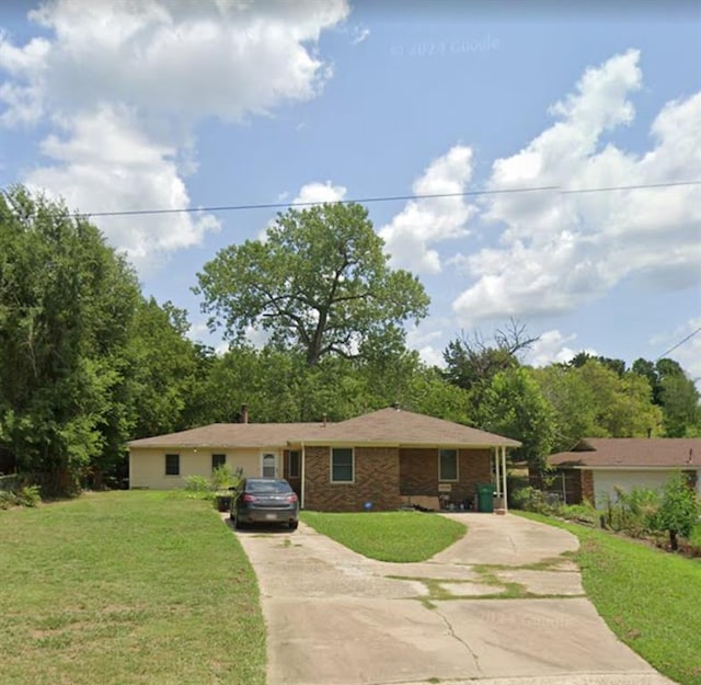 ranch-style house with brick siding, concrete driveway, and a front yard