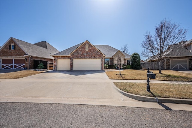 view of front of house featuring brick siding, an attached garage, driveway, and fence