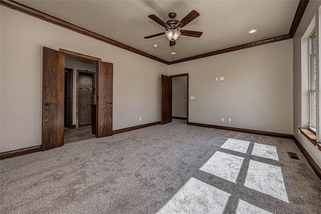 unfurnished bedroom featuring visible vents, carpet flooring, baseboards, and ornamental molding