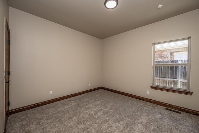 carpeted empty room featuring visible vents and baseboards