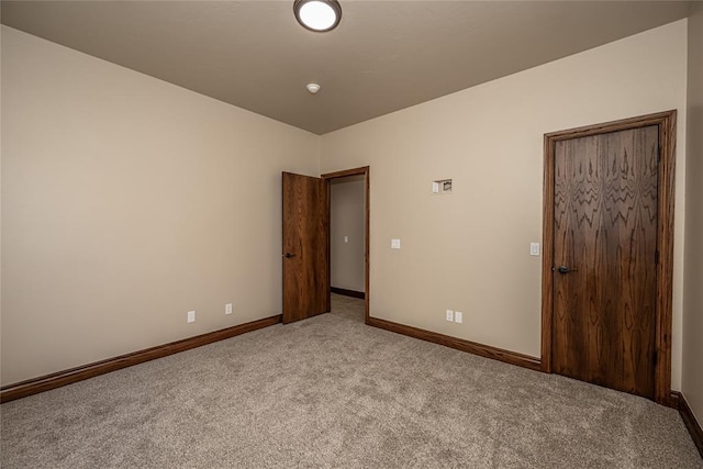 empty room with baseboards and carpet