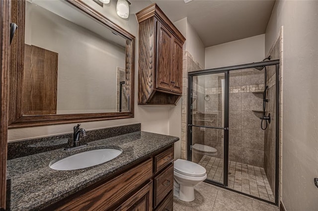 full bathroom with vanity, tile patterned floors, toilet, and a stall shower