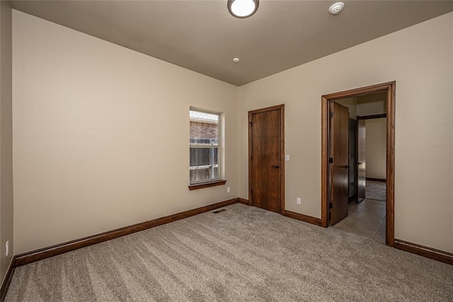 unfurnished bedroom featuring visible vents, carpet floors, and baseboards