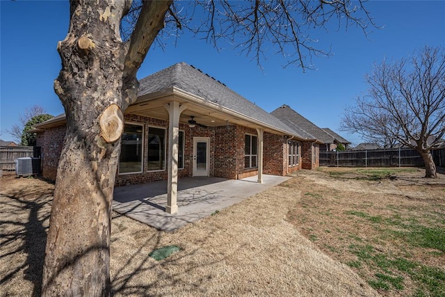 rear view of property with a patio, cooling unit, a ceiling fan, a fenced backyard, and brick siding