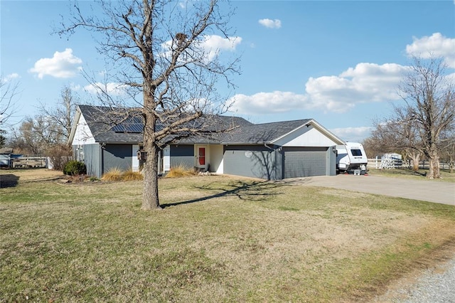 single story home with a front lawn, concrete driveway, a shingled roof, a garage, and solar panels