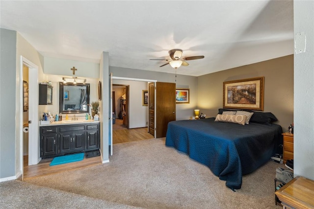 bedroom with a sink, baseboards, light carpet, and a ceiling fan