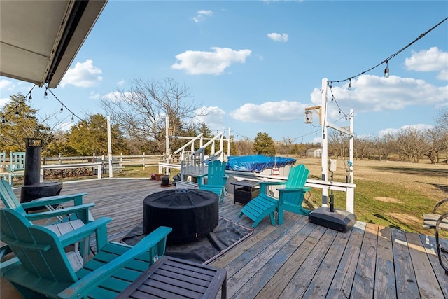 wooden deck with a fire pit and a lawn