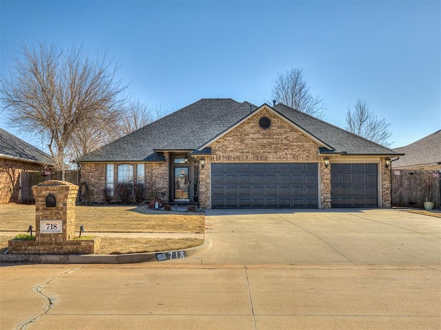 view of front of home featuring brick siding, concrete driveway, an attached garage, and a shingled roof