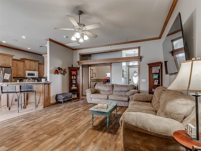 living room with visible vents, ceiling fan, light wood-type flooring, ornamental molding, and recessed lighting