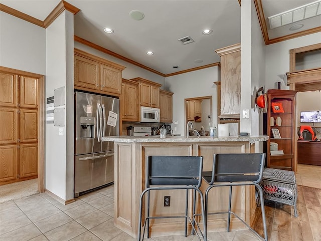 kitchen with white microwave, visible vents, recessed lighting, a peninsula, and stainless steel refrigerator with ice dispenser