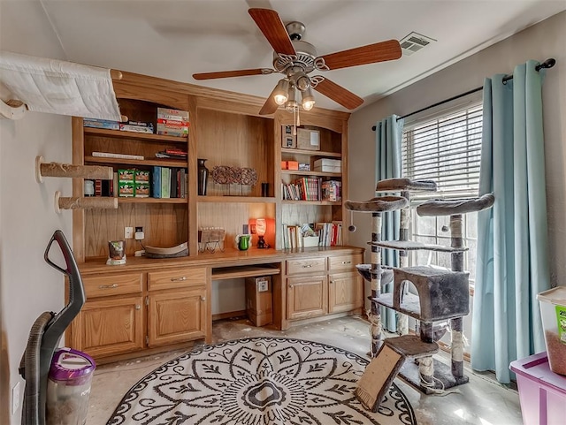 office space featuring visible vents, ceiling fan, and built in study area