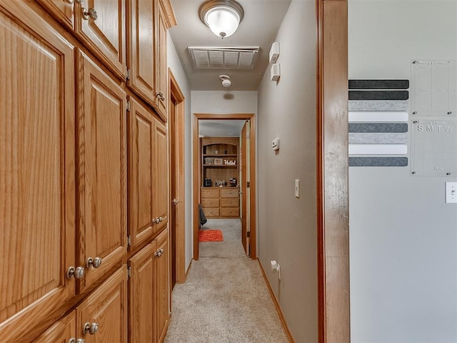 corridor featuring visible vents, light carpet, and baseboards