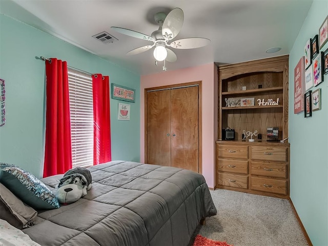 bedroom featuring a closet, visible vents, light colored carpet, and multiple windows