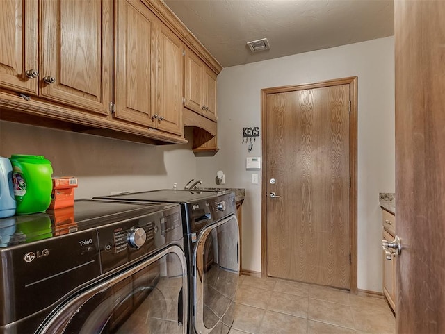 clothes washing area with visible vents, independent washer and dryer, cabinet space, light tile patterned flooring, and baseboards