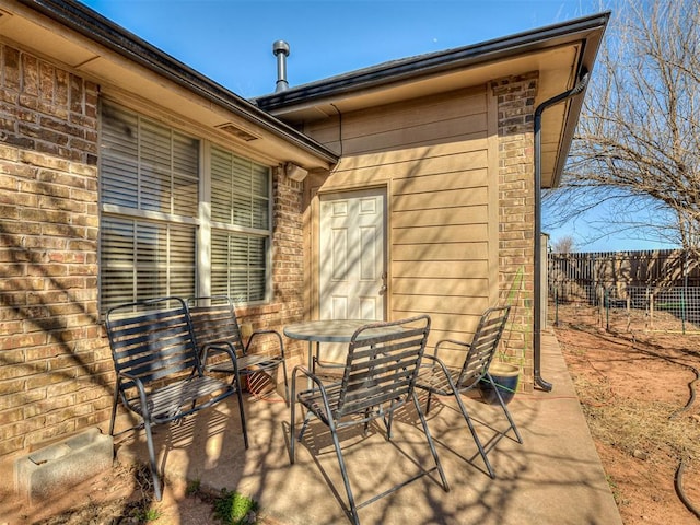 view of patio featuring outdoor dining area and fence