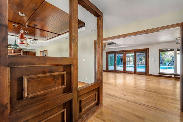 hall featuring wooden ceiling, baseboards, light wood-type flooring, and french doors