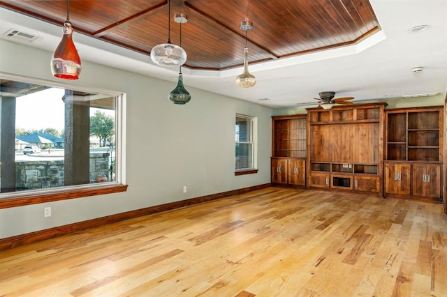 unfurnished living room featuring wood finished floors, baseboards, visible vents, a raised ceiling, and wooden ceiling