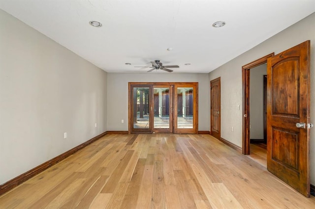 spare room with a ceiling fan, baseboards, and light wood-type flooring