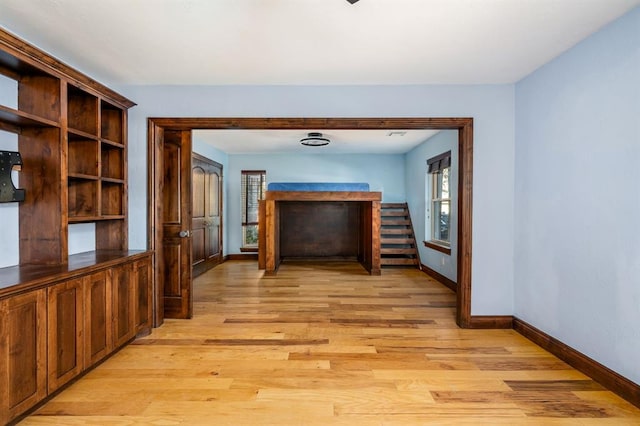 corridor with baseboards and light wood-style floors