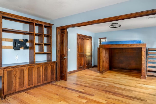 unfurnished bedroom featuring baseboards, visible vents, and light wood-type flooring