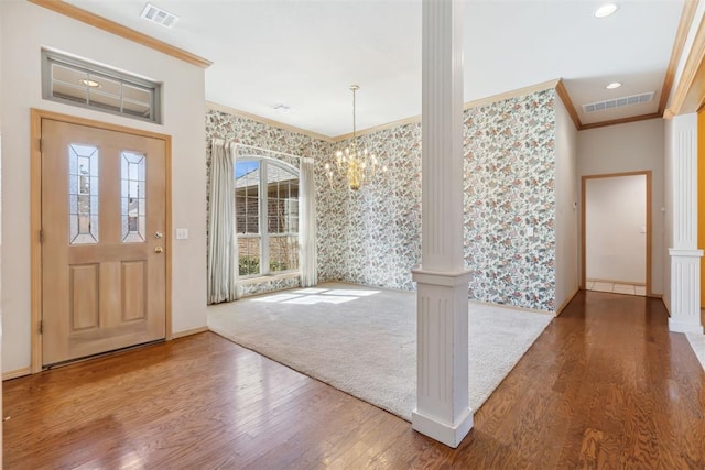 entrance foyer with decorative columns, visible vents, and ornamental molding