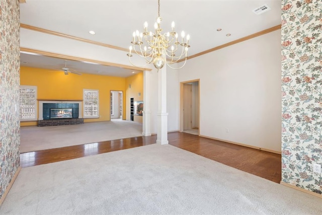 unfurnished living room featuring wood finished floors, a fireplace, visible vents, and ornamental molding