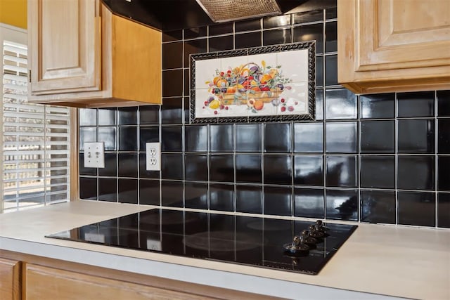 kitchen featuring light brown cabinetry, tasteful backsplash, light countertops, and black electric cooktop